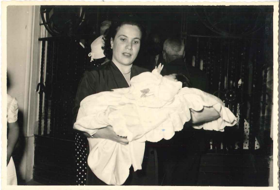  la sig.ra Stella mentre accompagna una bambina nel giorno del battesimo (Mesagne, 31.08.1958), coll. privata Famiglia Pezzolla 